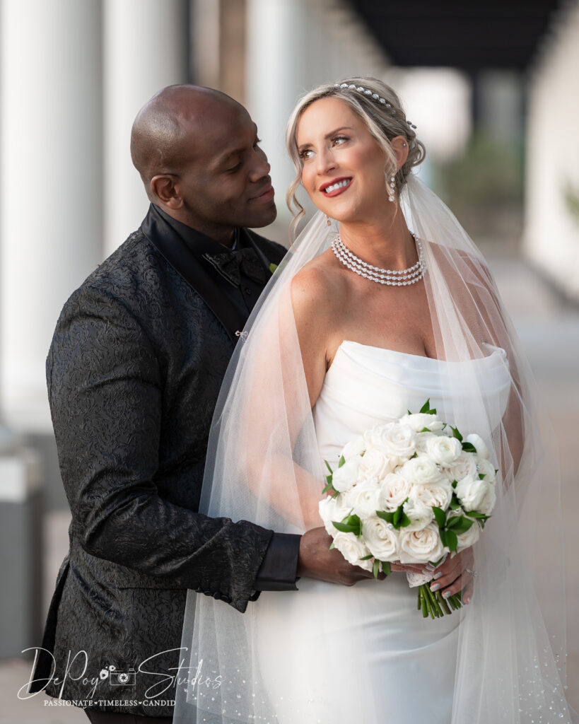 Interracial couple sharing a romantic moment on their wedding day at SoHo63 in Chandler, Arizona.