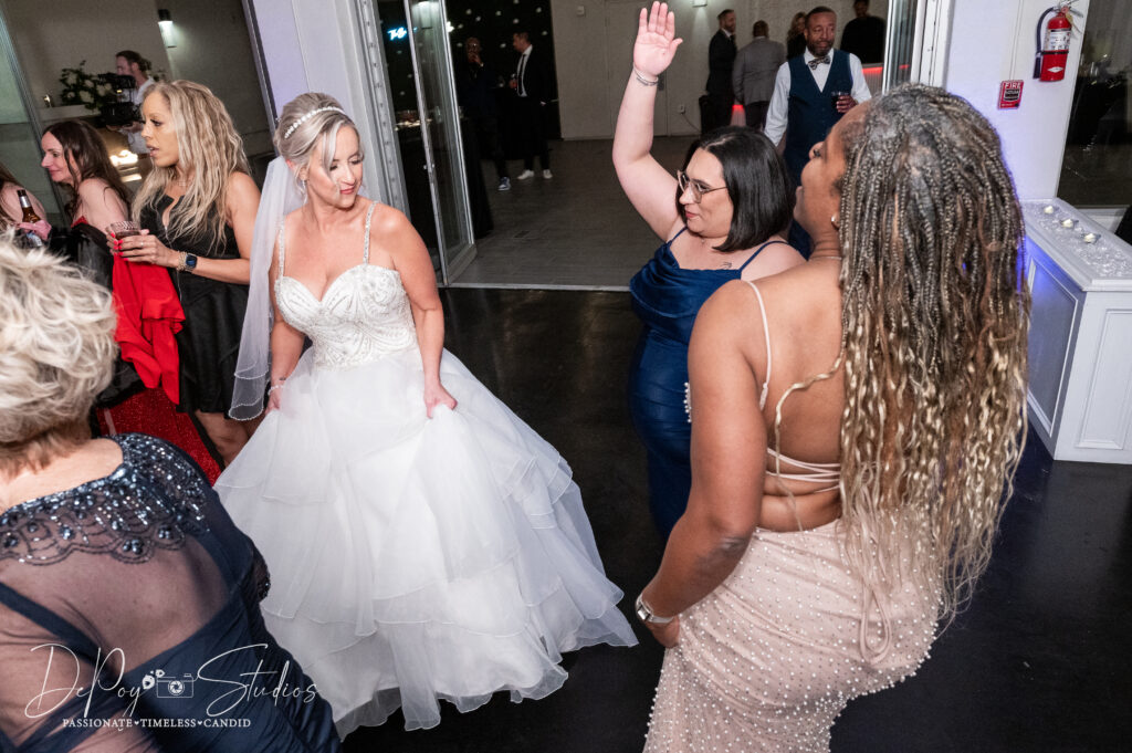 Lively dance floor moment at a SoHo63 wedding with guests cheering.